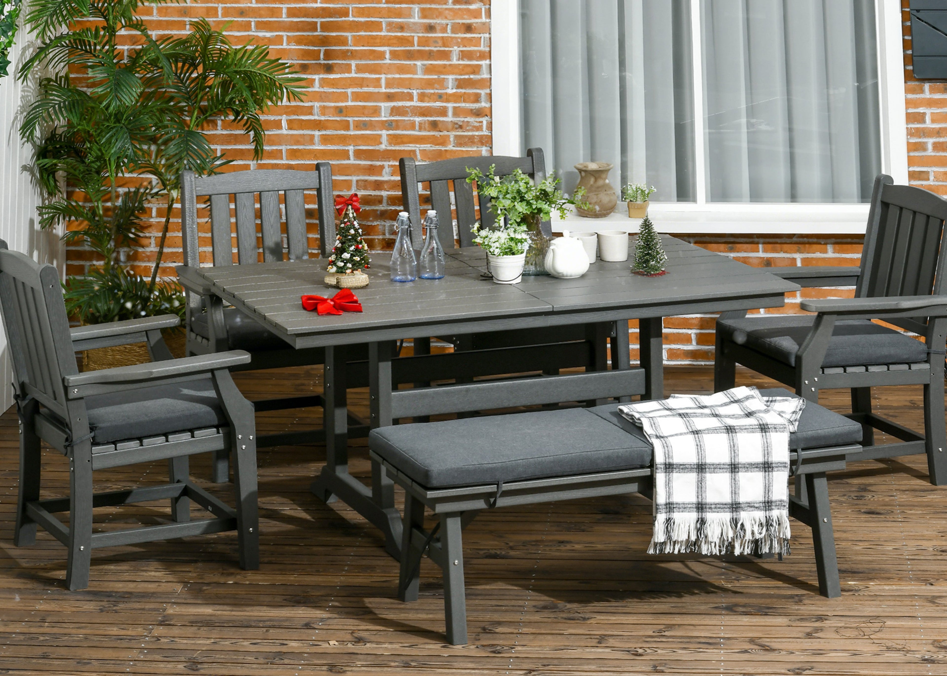 Outdoor patio set with table, chairs, and bench on a wooden deck.
